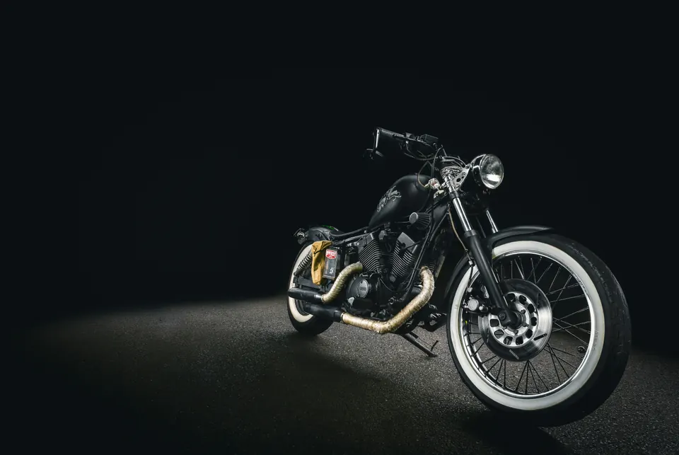 Moto de style bobber éclairée sur fond noir