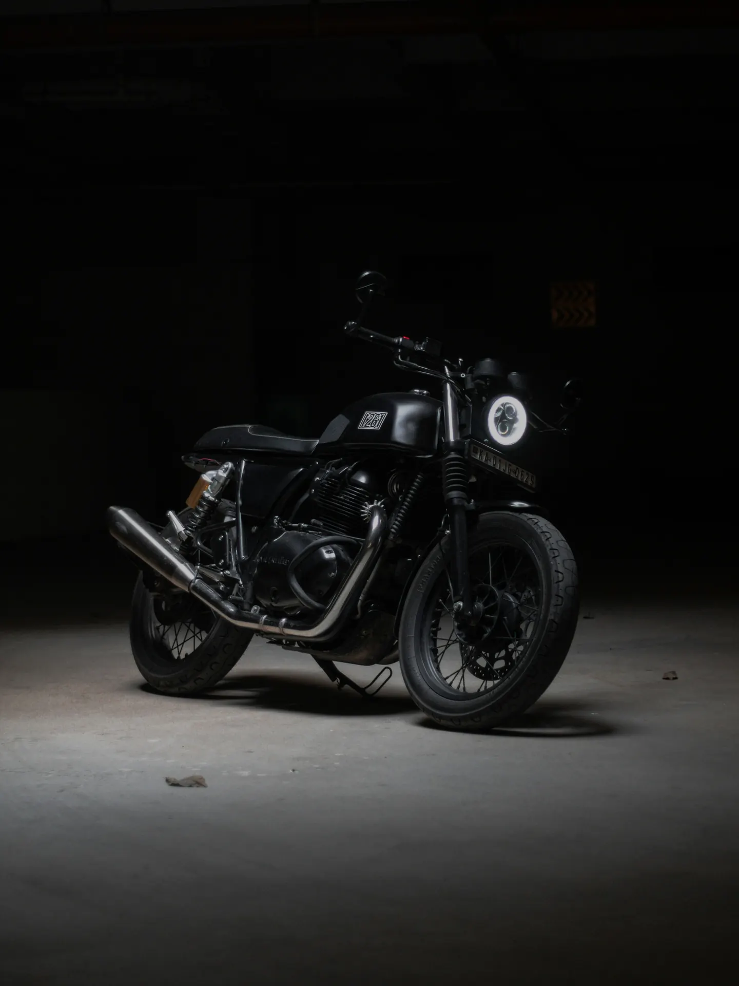 Moto café racer noire dans la pénombre